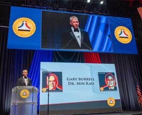 aviation-safety-hall-of-fame-garmin-induction-ceremony-with-presentation-screen-in-background-and-speaker-on-stage